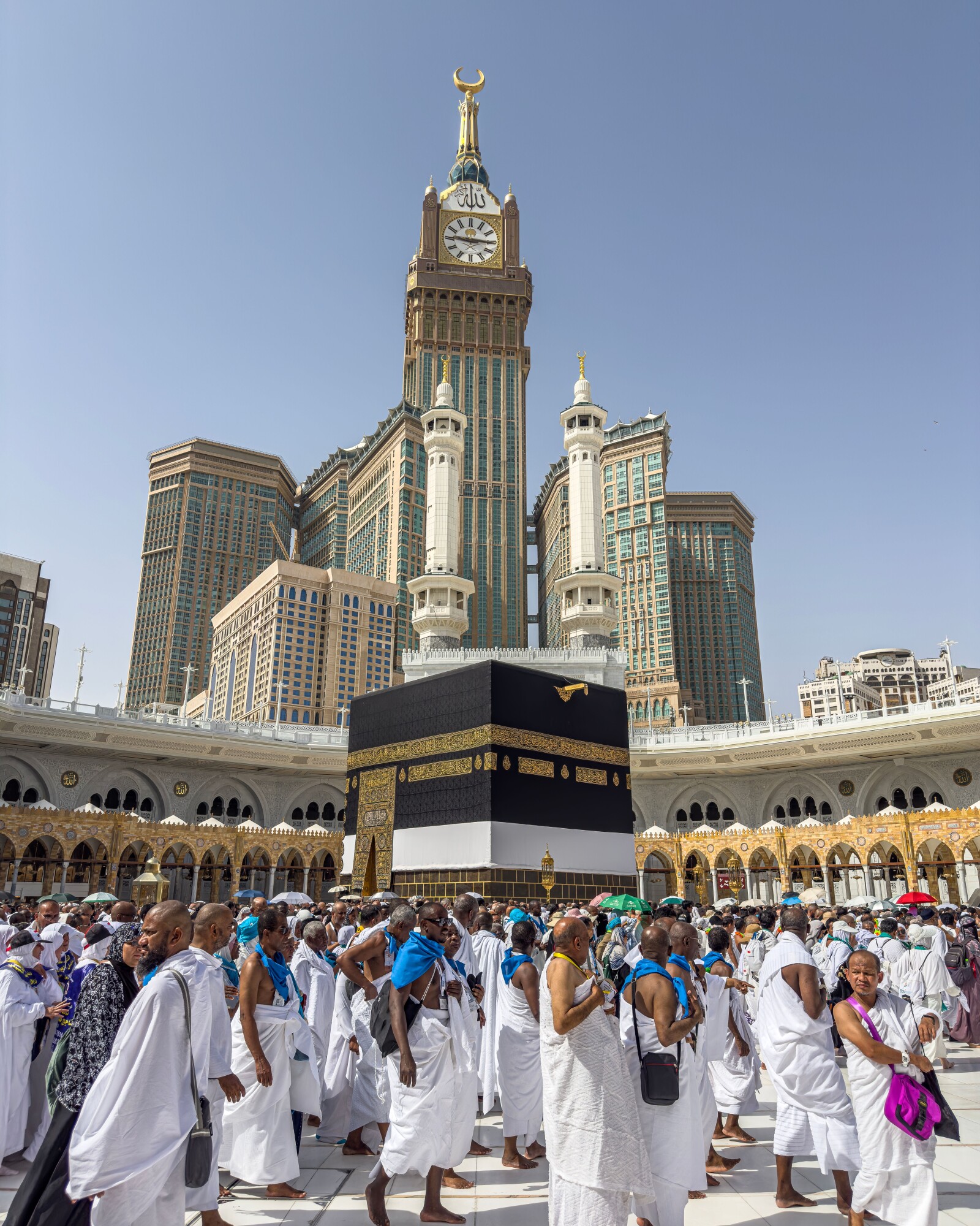 The Kaaba and the Makkah clock tower, with pilgrims in Masjid al-Haram