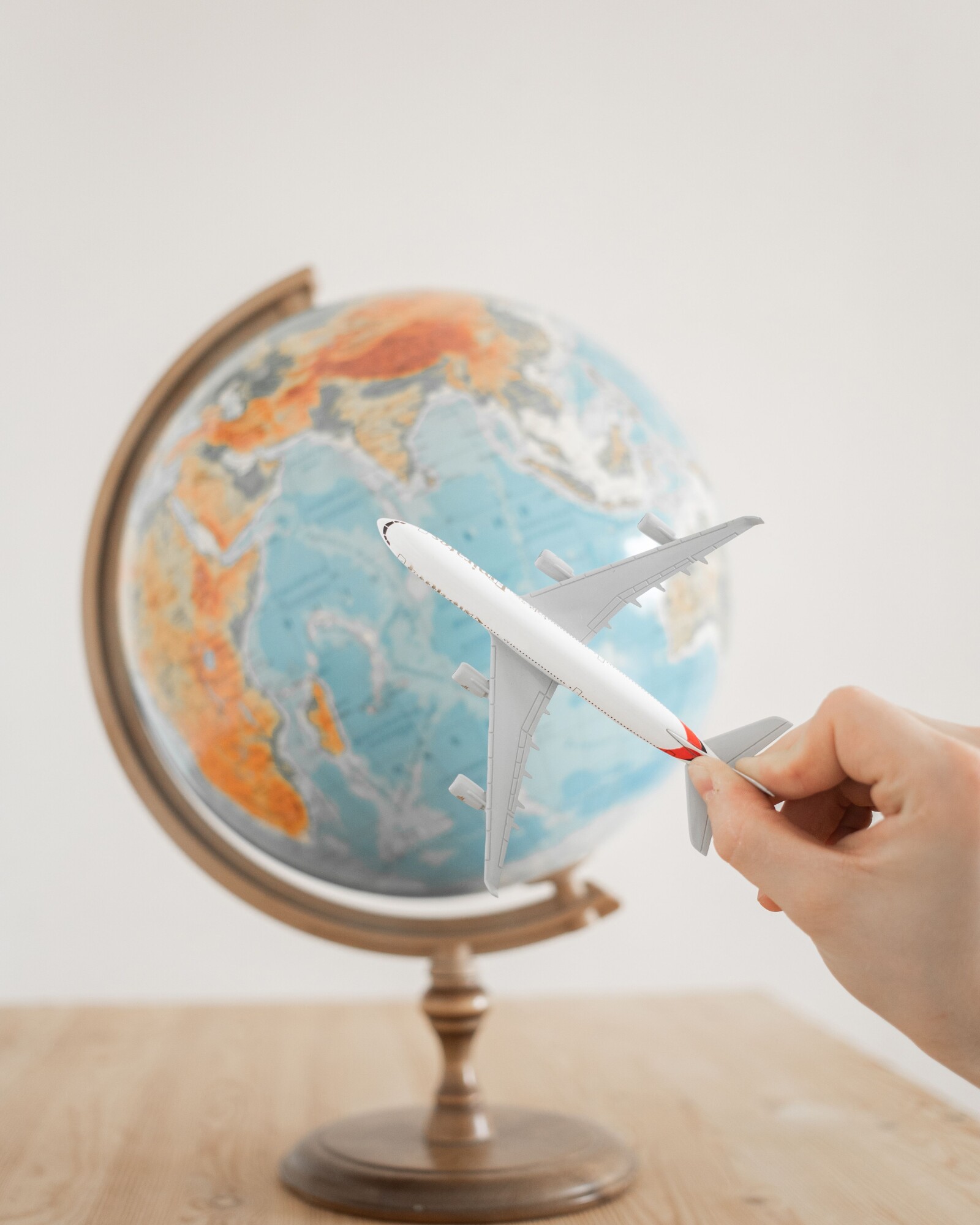 A toy aeroplane held over a globe